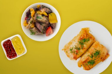  sebze salatası ve soslu beyaz bir tabakta lahana rulosu.. 