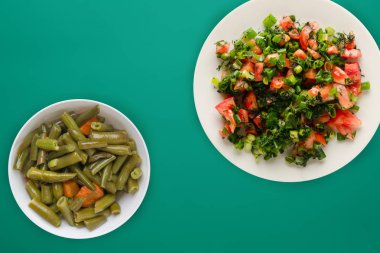  Vejetaryen yemeği. Domatesler, soğanlar, beyaz bir tabakta C üzerine dereotu.