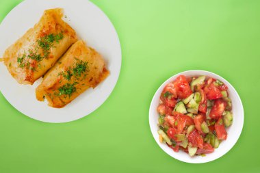  sebze salatası ve soslu beyaz bir tabakta lahana rulosu.. 
