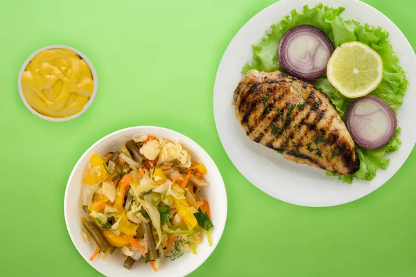 Gegrilltes Huhn mit Gemüse Zitrone, Salat, Zwiebel) auf einer Farbe — Stockfoto