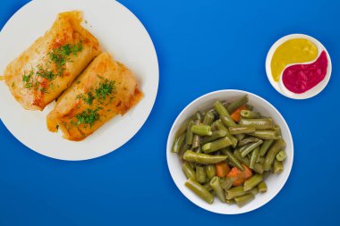  sebze salatası ve soslu beyaz bir tabakta lahana rulosu.. 