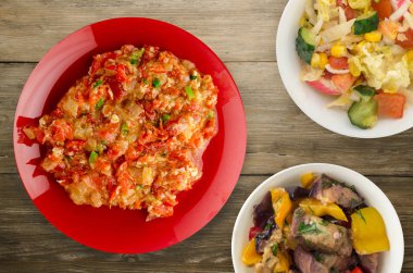 Ahşap arka plan üzerinde bir tabak içinde soğan ile haşlanmış domates 