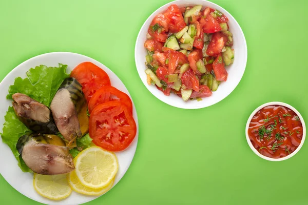 Sliced mackerel with lettuce, tomatoes and lemon on a white plat — Stock Photo, Image