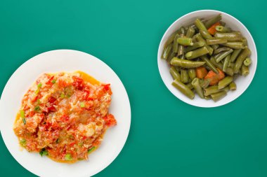  Renkli sırtında beyaz bir tabakta soğanlı haşlanmış domates.