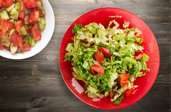 Salat aus Kohltomaten auf einem Teller auf einem hölzernen Hintergrund — Stockfoto