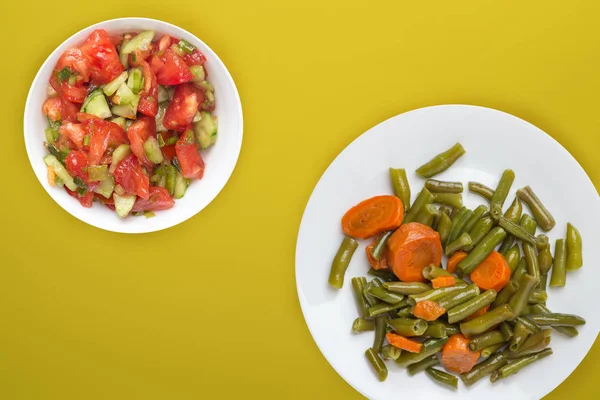 Green beans with garlic carrots on a white plate on a colored b — Stock Photo, Image