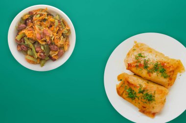  sebze salatası ve soslu beyaz bir tabakta lahana rulosu.. 