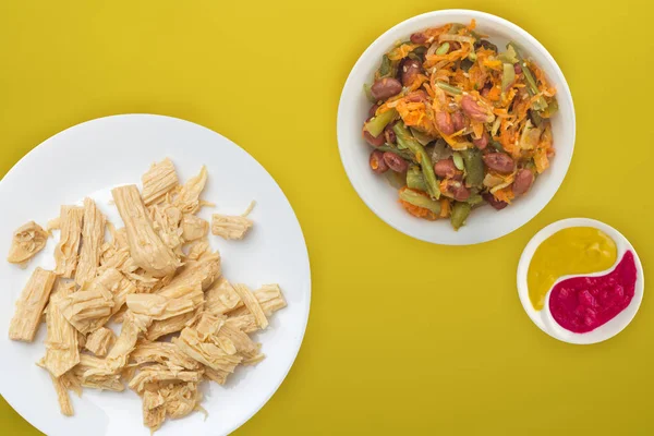 Fideos de espárragos de soja en un plato blanco sobre un fondo de color . — Foto de Stock