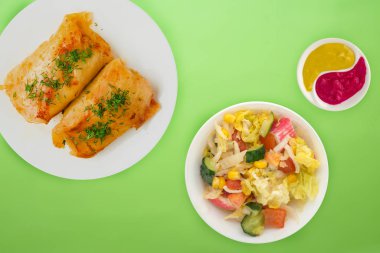  sebze salatası ve soslu beyaz bir tabakta lahana rulosu.. 