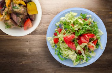  ahşap arka plan üzerinde bir tabakta lahana domates salatası