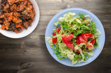  ahşap arka plan üzerinde bir tabakta lahana domates salatası