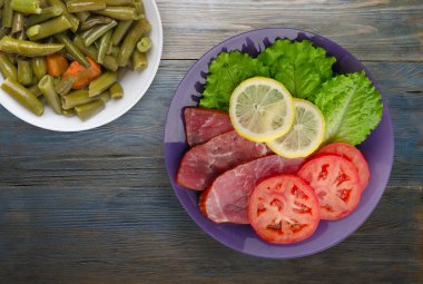 jambon salatası, domates ve limon bir plaka üzerinde. 