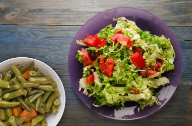  ahşap arka plan üzerinde bir tabakta lahana domates salatası