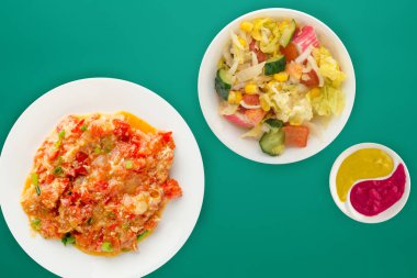  Renkli sırtında beyaz bir tabakta soğanlı haşlanmış domates.