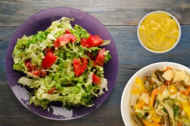  ahşap arka plan üzerinde bir tabakta lahana domates salatası