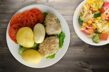 Beyaz tabakta patates pirzolası. Patatesli pirzola.