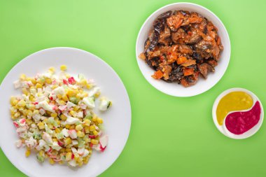 Beyaz tabakta yengeç salatası. Renkli arkaplanda yengeç salatası