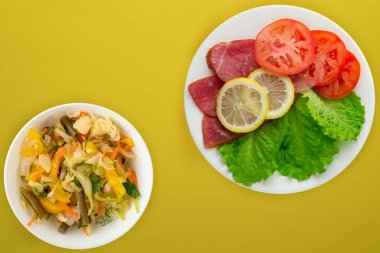  Beyaz tabakta salatalı, domatesli ve limonlu jambon. Domuz eti.