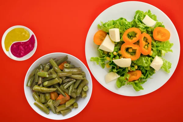 Salad of cheese, lettuce, corn, pepper on a colored  background — Stock Photo, Image