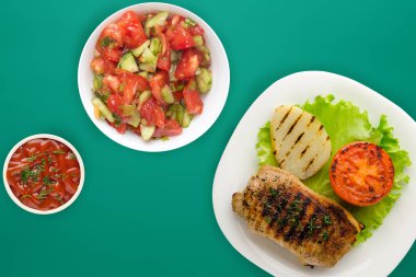  Renkli bir arka planda patates ve domatesli ızgara domuz eti