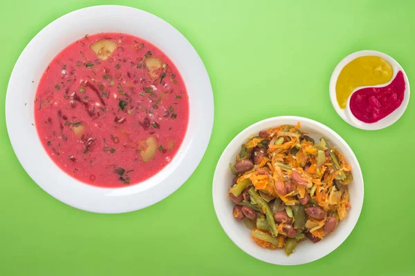 La sopa de remolacha un plato blanco con ensalada de verduras sobre un fondo de color. Almuerzo vegetariano . — Foto de Stock