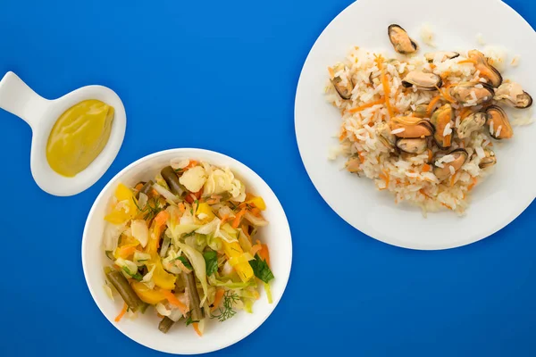 Ris med musslor och morötter på en vit tallrik. ris med musslor — Stockfoto