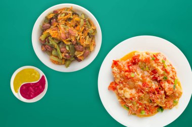  Renkli sırtında beyaz bir tabakta soğanlı haşlanmış domates.