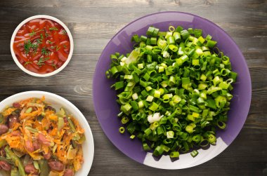 soğan ve dereotu ahşap arka plan üzerinde bir plaka üzerinde