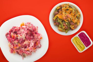 Beyaz bir tabakta kürk manto altında ringa balığı. Renkli bir arkaplanda kürkün altında ringa balığı. Ringa, pancar, havuç, mayonez ve soğan salatası. .