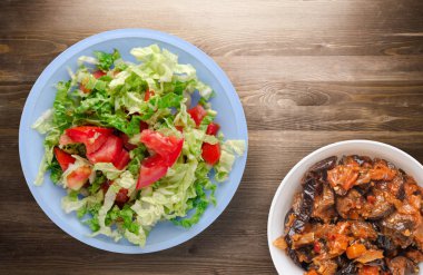  ahşap arka plan üzerinde bir tabakta lahana domates salatası