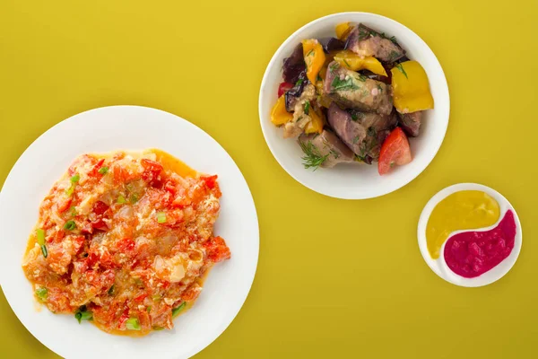  Renkli sırtında beyaz bir tabakta soğanlı haşlanmış domates.