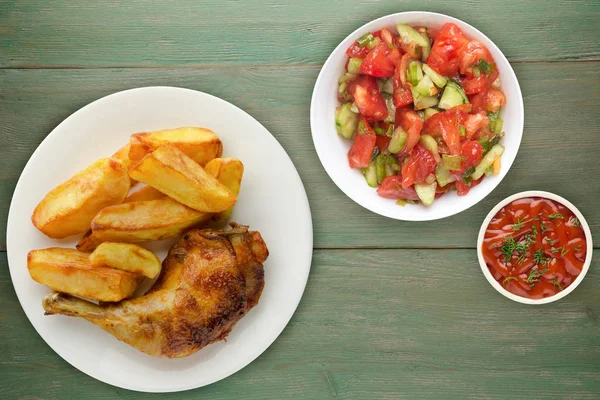 Ahşap arka plan üzerinde tavuk uyluk patates kızartması ile. 