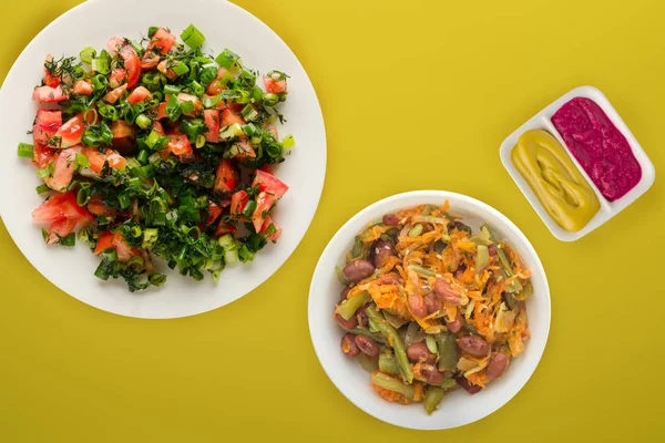  Vejetaryen yemeği. Domatesler, soğanlar, beyaz bir tabakta C üzerine dereotu.