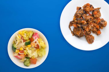 Beyaz bir tabakta renkli bir arka planda domates ve biberli kabak yahnisi. Vejetaryen yemeği. Sağlıklı kahvaltı manzarası