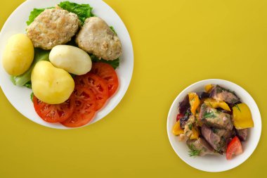 Beyaz tabakta patates pirzolası. Renkli arkaplanda patatesli pirzola.