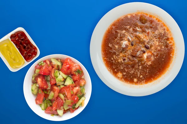 Borscht soup on a colored background. Borscht soup with sour cream and with vegetable salad. healthy lunch top view — 스톡 사진