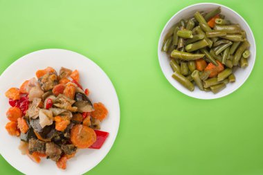 Beyaz tabakta sebze güveci. Renkli arka planda haşlanmış sebzeler. vejetaryen yemeği