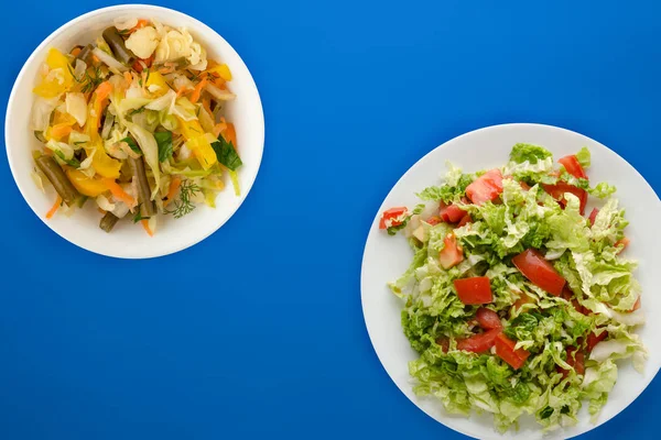 Nourriture végétarienne. tomates, oignons, aneth sur une assiette blanche sur un fond coloré. aliments sains — Photo