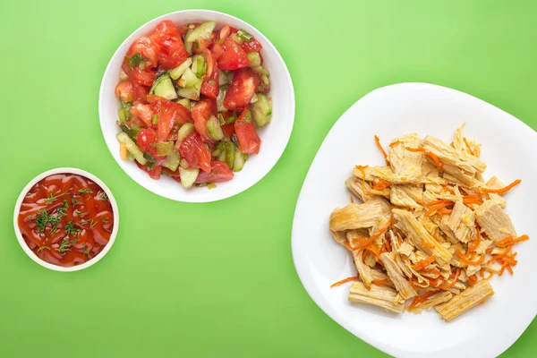 Espárragos de soja y ensalada de zanahoria en un plato blanco. espárragos de soja sobre un fondo de color. comida asiática vista superior. Comida vegetariana — Foto de Stock