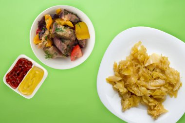 Renkli arka planda beyaz bir tabakta haşlanmış lahana. Haşlanmış lahana manzaralı. Sağlıklı yemek. vejetaryen yemeği .