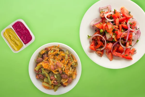 素食。 西红柿、洋葱、白盘上的小茴香、彩色底色。 健康食品 — 图库照片