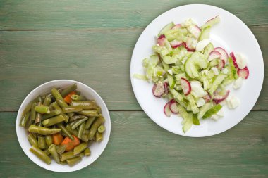 Salatalıklı salata ve beyaz tabakta yumurta yeşil ahşap arka planda sağlıklı yemek. Vejetaryen yemeği. Asya mutfağı