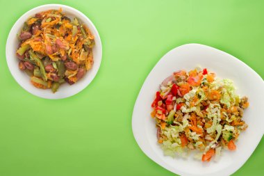 Tavuk mideli salata ile sebze havuç, soğan, biber, lahana, domates, brokoli. Limonlu beyaz tabakta tavuklu salata.
