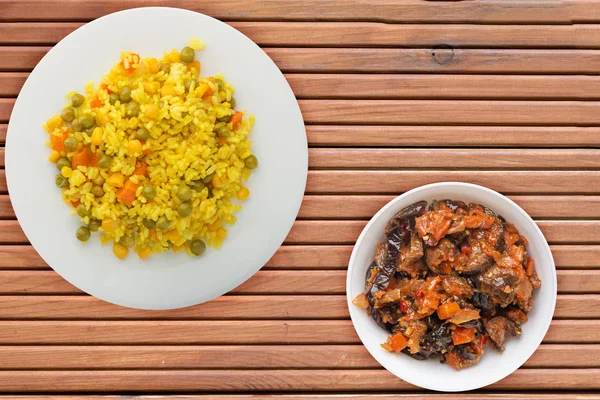 Asian healthy food. yellow rice on a white plate with vegetables. healthy food on a orange wooden background top view.flat lay