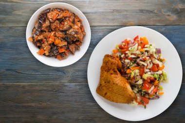 Mavi ahşap arka planda sebze salatalı tavuk kanadı. Sebzeli tavuk kanadı.