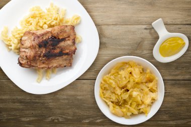 Izgara domuz pirzolası ve makarna. Ahşap bir zeminde ızgara domuz pirzolası. Izgara domuz pirzolası.