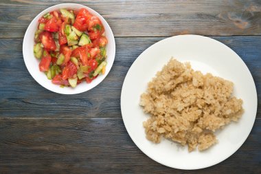 Beyaz tabakta soya soslu beyaz pirinç. Mavi ahşap arka plan manzaralı sebze salatalı pirinç. Asya yemekleri.