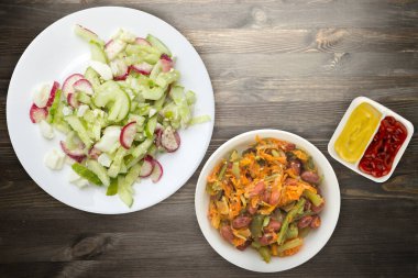 Salatalıklı salata ve siyah ahşap arka planda beyaz bir tabakta yumurta. Sağlıklı yemek. Vejetaryen yemeği. Asya mutfağı