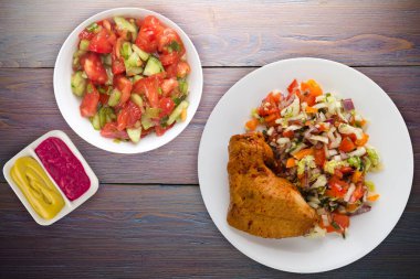 chicken wing with vegetable salad on a purple wooden background. chicken wing with vegetables on a plate.