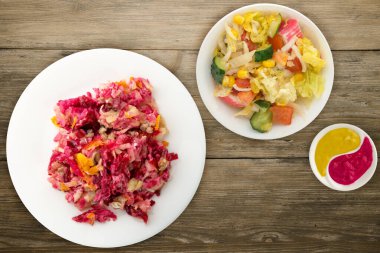 Beyaz bir tabakta kürk manto altında ringa balığı. Ahşap bir arka planda kürk mantonun altında ringa balığı. Ringa, pancar, havuç, mayonez ve soğan salatası. .